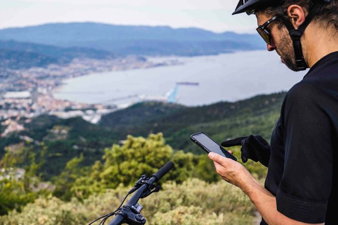 Canyon Smartphone App. Ein Biker hält sein Smartphone in der Hand.