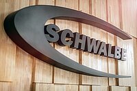 Schwarzer Schriftzug Schwalbe auf einer Holzwand