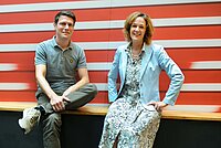 Ein Mann und eine Frau sitzen auf einer Bank.