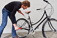 Eine Mann knackt ein Fahrradschloss.
