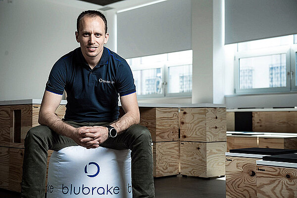 Blubrake E-Bike ABS. Ein Mann sitzt auf einem Hocker.