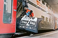 Velotransport in selbst genähten Tragetaschen nicht erlaubt. Ein Mann trägt sein Fahrrad in einer Tasche.