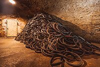 Radl-Ruhland führt 20000 alte Fahrradreifen dem Schwalbe Reifenrecycling zu. In einem Keller lagert ein grosser Stapel alter Fahrradreifen. 