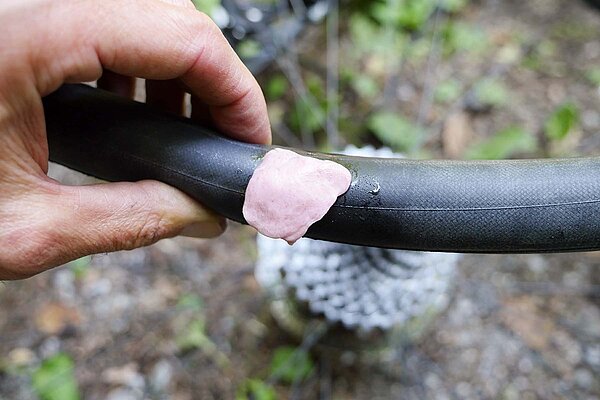 Fahrradpanne Unterwegs Loch im Schlauch mit Kaugummi flicken. 