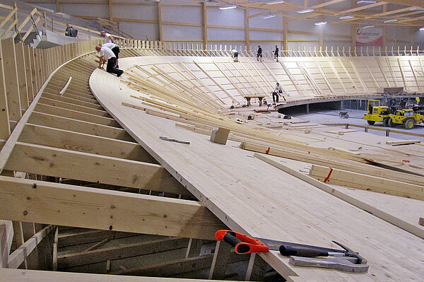 Arbeiter bauen eine Bahn aus Holz für Fahrradrennen. 