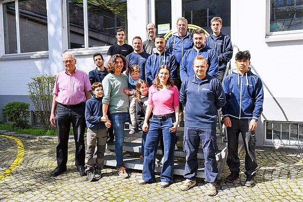 Eine Gruppe von Personen steht vor einem Haus.