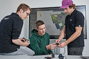 Flyer Biketec ZEG. Drei Männer besprechen etwas in einem Sitzungszimmer. 