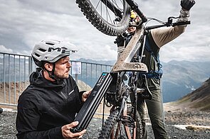 Ein Mann wechselt den Akku eines E-Mountainbikes aus.