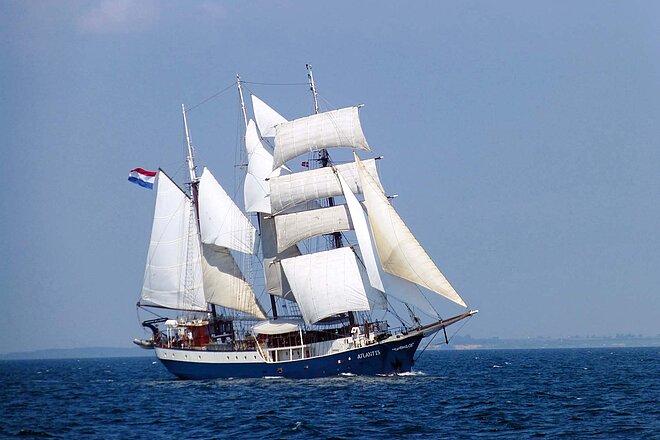 Nach zwei Jahren Flaute spürt die Reisebranche wieder Rückenwind. Ein Segelschiff mit weissen Segeln im Meer.