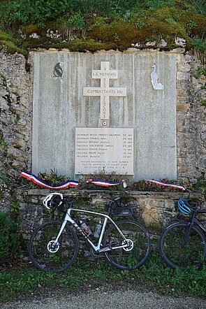 Ein Fahrrad steht in Frankreich vor einer Gedenktafel für die Résistance