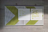 Schild, das Radfahrenden den Weg zu einem Veloparking weist. 