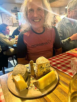 Ein Mann mit langen Haaren sitzt an einem Tisch.