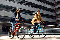 Shimano Cues Update. Zwei Personen fahren auf Rennrädern durch die Stadt.