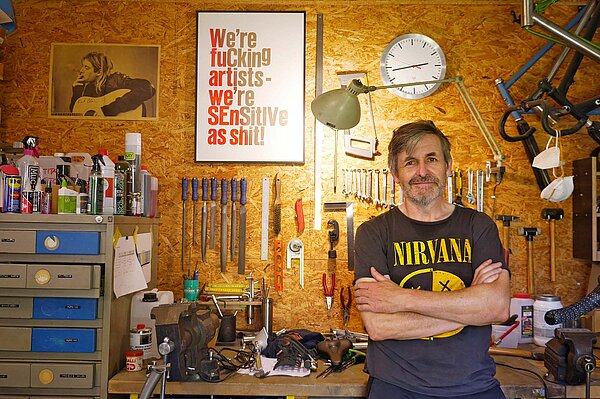 Ein Mann steht in einer Werkstatt. 