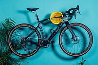 Cycloc Wandhalterung für Fahrräder. Ein Fahrrad hängt an einer blauen Wand.