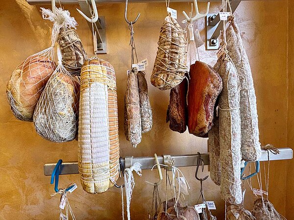 Würste hängen an Haken.