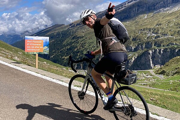 Klausen Monument war ein Velofest. Rennvelfahrer winkt in die Kamera.