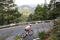 Eine Frau fährt mit dem Rennrad auf einer Passstrasse.