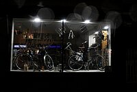 Die Konsumentenstimmung ist im Juli 2022 auf einem historischen Tiefstand. Schaufenster eines Fahrradladens im Dunkeln. 