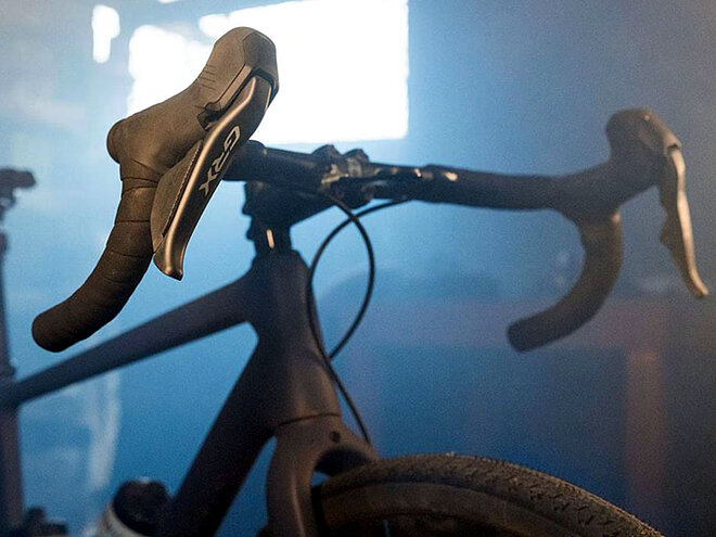 alt="Fahrrad mit Rennradlenker und Shimano-GRX-Bremshebeln.