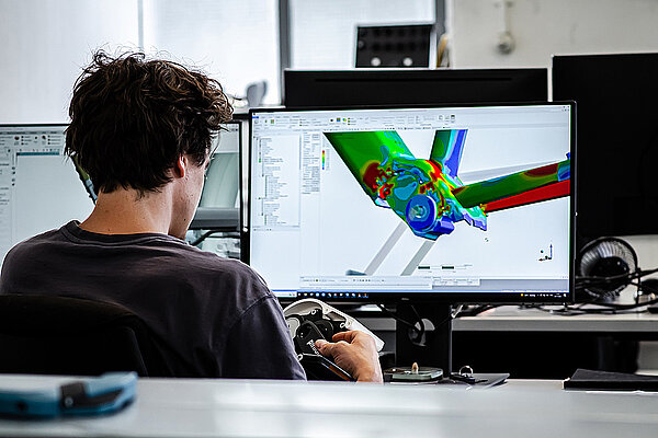 Radiate Engineering & Design. Eine Person sitzt vor einem Computer. 