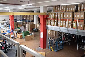 Veloplus Velos und Zubehör. Lagerhalle mit Fahrradkartons.
