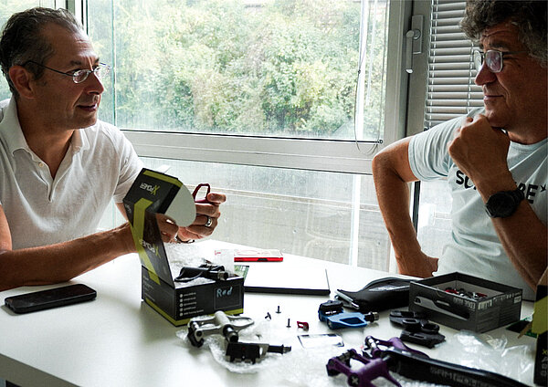 Zwei Männer sitzen an einem Tisch. 