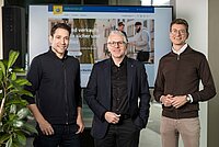 TCS übernimmt Velocorner. Drei Männer posieren für ein Foto. 