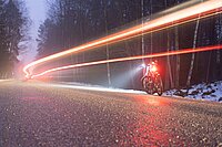 Lichtschweif neben Fahrrad im dunkeln. So sind die Velolichtregeln in der Schweiz.