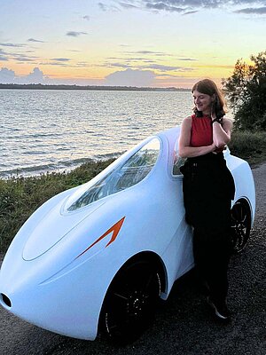 Eine Frau steht neben einem vollverschalten E-Bike.