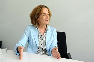 Eine Frau sitzt an einem Bürotisch.