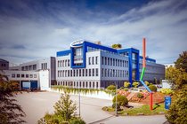 Reifenhersteller Schwalbe meldet Umsatzrekord. Firmengebäude mit blauem Dach.