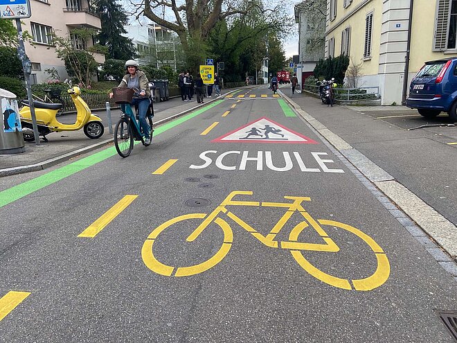 Die neue Velovorzugsroute im Zürcher Seefeld kommt mit viel Farbe und Markierungen daher. Velovorzusgroute Seefeld beim Schulhaus Mühlebach mit Velowegmarkierung und Piktogrammen