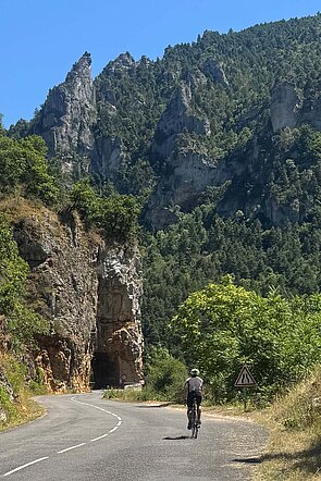 Radfahrer vor Felskulisse.