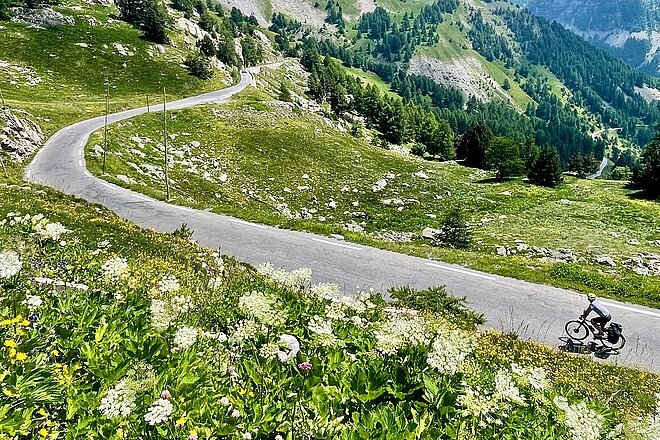 Radfahrer auf einer Strasse in den Bergen.