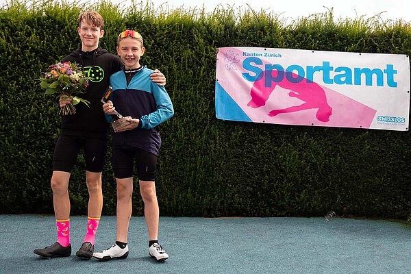 Bergzeitfahren Buchenegg Ostwand. Zwei junge Männer stehen mit Fahrradbekleidung auf einem Podest. 