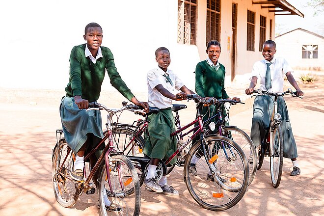 vier junge Frauen mit dem Velo unterwegs zur Schule
