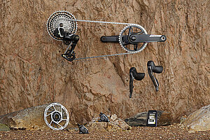 Teile einer Fahrradschaltung von Sram liegen auf Sandstein.