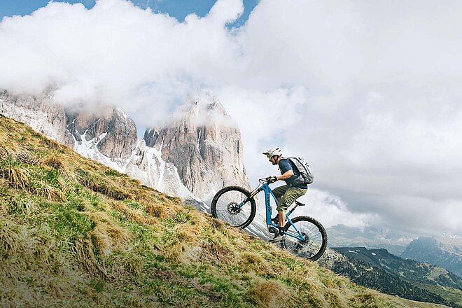 Ein Mann fährt auf dem E-Mountainbike einen Berg hoch.