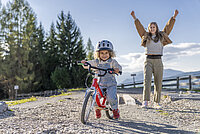 Kind mit Woom-Velo und Mutter.