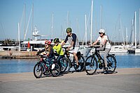 Accell Group wird herabgestuft. Eine Familie fährt auf Velos ein Hafenbecken entlang. 