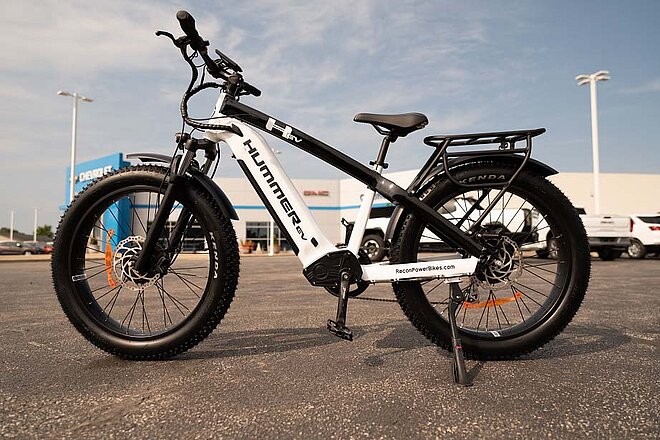 Hummer baut jetzt auch E-Bikes. Weisses SUV E-Bike auf einem Parkplatz.