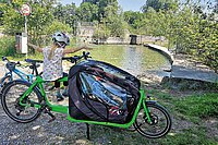 Locker durch die Schweiz radeln: Vier Routen zwischen Bodensee und Genfersee. Ein Kind sitzt auf einen grünen Cargobike.