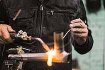 Eine Person löhtet einen Fahrradrahmen. 