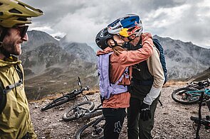 Ein Paar mit Mountaibike-Bekleidung küsst sich. 