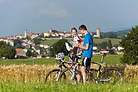 Eine junge Frau und ein junger Mann studieren eine Landkarte neben ihren Velos