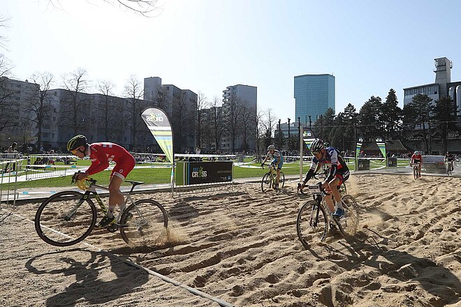 Rennradfahrer fahrer während eines Cyclocross-Rennens durch den Sand.