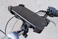 Ein Smarphone ist mit einem Halter an einem Velolenker befestigt.