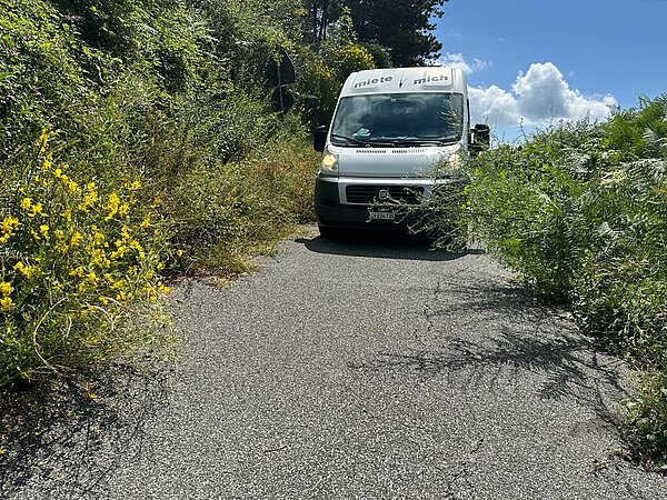 Auto auf einer schmalen Strasse in Italien.