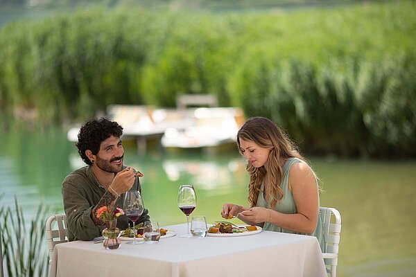 Ein Mann und eine Frau sitzen mit einem Glas Wein an einem Tisch.